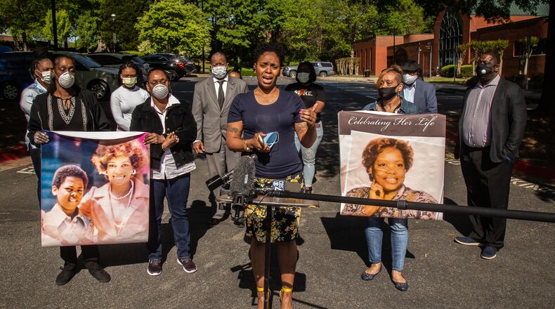 Tilafayea Walker speaks at a press conference in April while other family members of Nancy Finney hold up photographs. Finney, 73, died of COVID-19 while living at the Arbor Terrace at Cascade senior care facility in Fulton County. (Steve Schaefer / Special to the AJC)