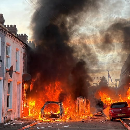 Vehicles set on fire by protesters burn on Lendrick Street in east Belfast, Northern Ireland, on Tuesday, June 9, 2026, after the arrest of a Sudanese man accused of stabbing a man in the northern part of the city. (PA via AP)