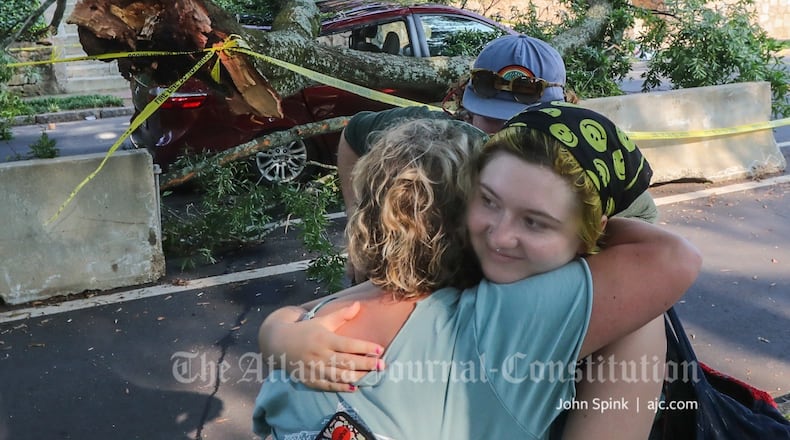 Elizabeth O'Brien hugs her daughter Violet Reynolds O'Brien (right) after their minivan was crushed Friday morning by a falling tree. The entire family walked away unscathed.