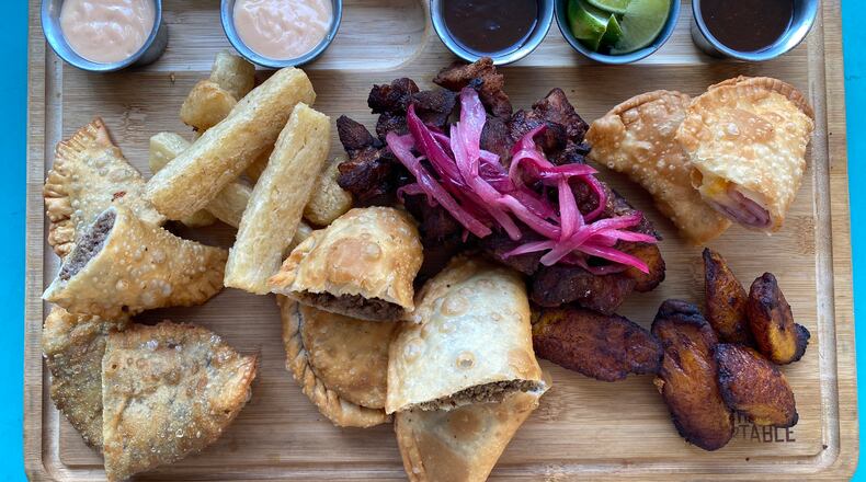 A tabla from Raul's Latin Kitchen brings a selection of Puerto Rican appetizers, including empanadas, carne frita and maduros. (Ligaya Figueras / ligaya.figueras@ajc.com)