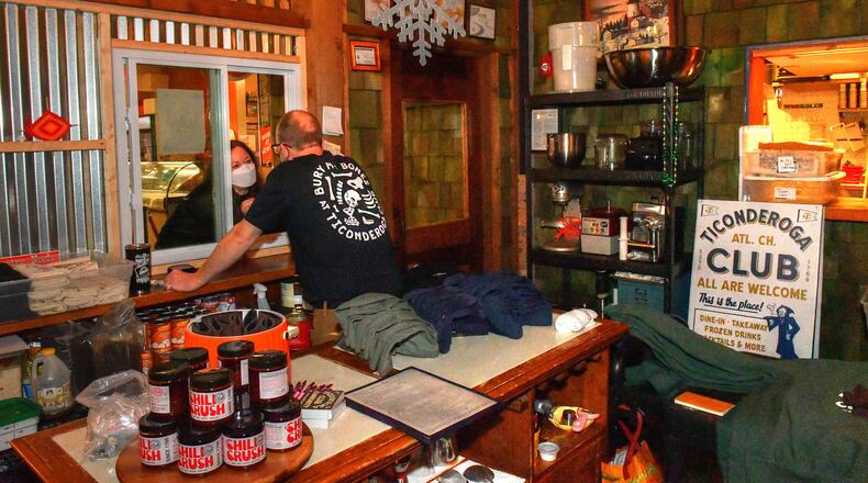 211220 Atlanta, Ga: Ticonderoga Club co-owner Greg Best (at window) converses with a walk-up customer at the Club's Krog Street Market. (Chris Hunt for The Atlanta Journal-Constitution)