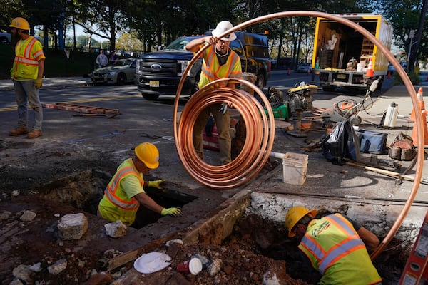 FILE - Workmen prepare to replace older water pipes with a new copper one in Newark, N.J., Oct. 21, 2021. (AP Photo/Seth Wenig, File)
