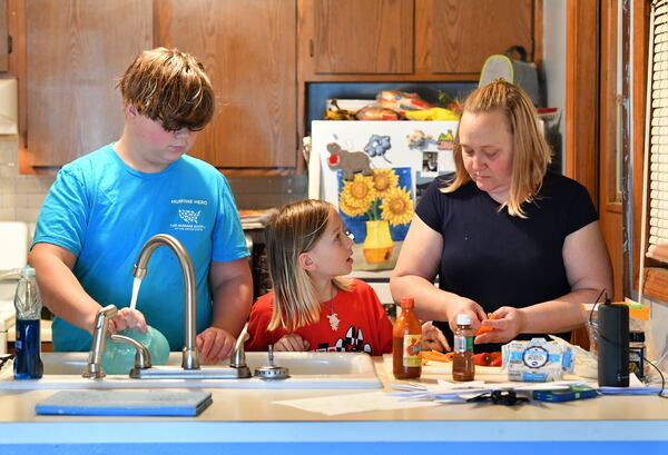Jennifer Paris is preparing snacks for her two children Peyton, 12, and Cason, 10, after they finished their homework online at their home in Acworth on Friday, November 13, 2020.  (Hyosub Shin / Hyosub.Shin@ajc.com)