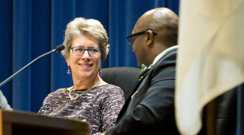 New DeKalb County Presiding Officer Kathie Gannon, left, talks with Greg Adams during the DeKalb County Board of Commissioners meeting Tuesday. STEVE SCHAEFER / SPECIAL TO THE AJC