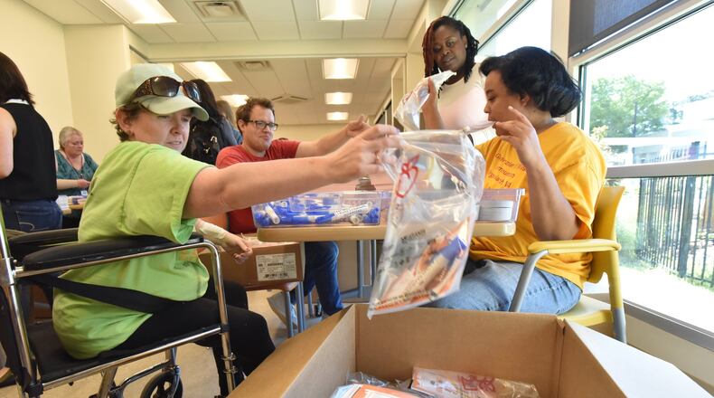 June 14, 2019 Atlanta - For the past 20 years, Jewish Family and Career Services has organized the bags handed to finishers at the end of the race — a job that also requires keeping the AJC Peachtree Road Race T-shirt design a secret. Volunteers Heather Porter (left) and Frances Williams (right), both clients at the center, lend a hand. HYOSUB SHIN / HSHIN@AJC.COM