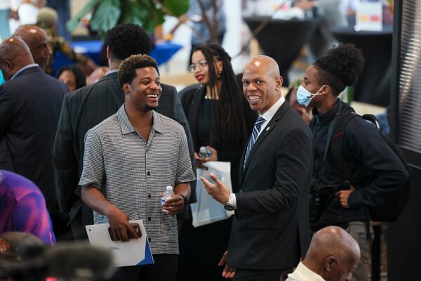Atlanta City Councilmember Jason Dozier (right), representing District 4, talks with a man attending the launch of a program to support and recognize legacy businesses at the Pittsburgh Yards, Tuesday, April 1, 2025, in Atlanta. (Jason Getz / AJC)