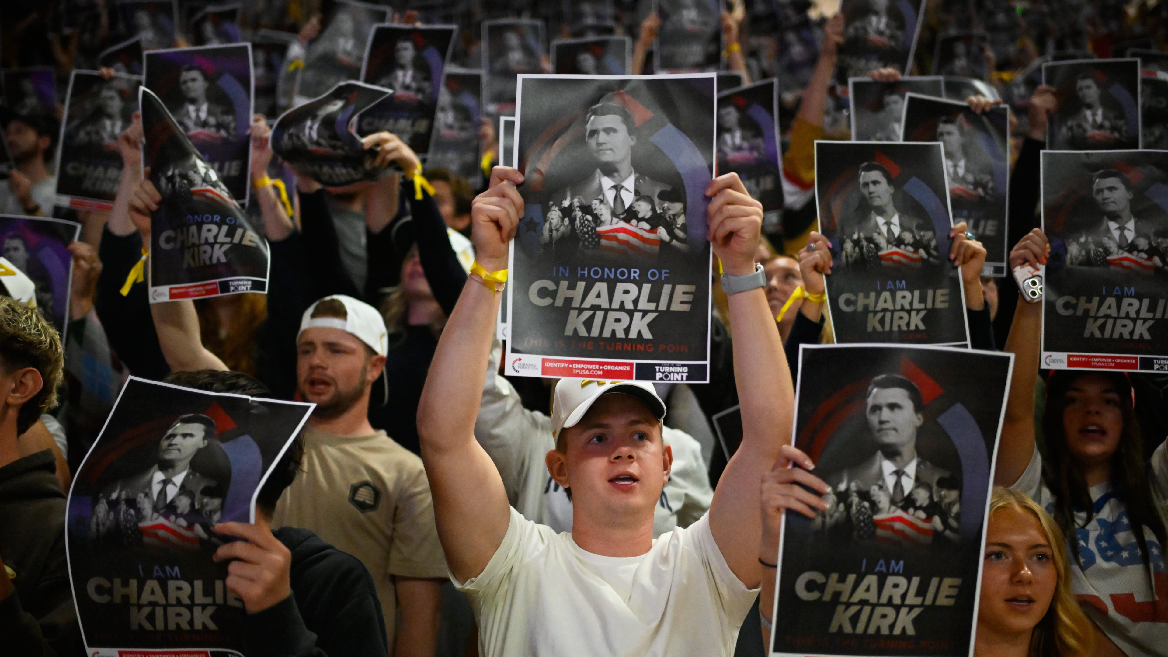 People hold posters of Charlie Kirk during a Turning Point USA rally at Utah State University, as a part of the organization's push to memorialize Kirk, Tuesday, Sept. 30, 2025, in Logan, Utah. (AP Photo/Alex Goodlett)
