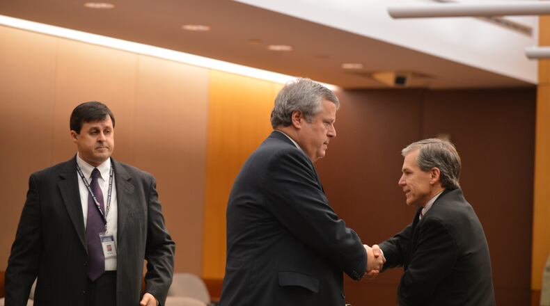 Don Balfour, center, shakes hands with assistant attorney general Greg Greg Lohmeier as he enters the court room on Monday, Dec. 16, 2013.