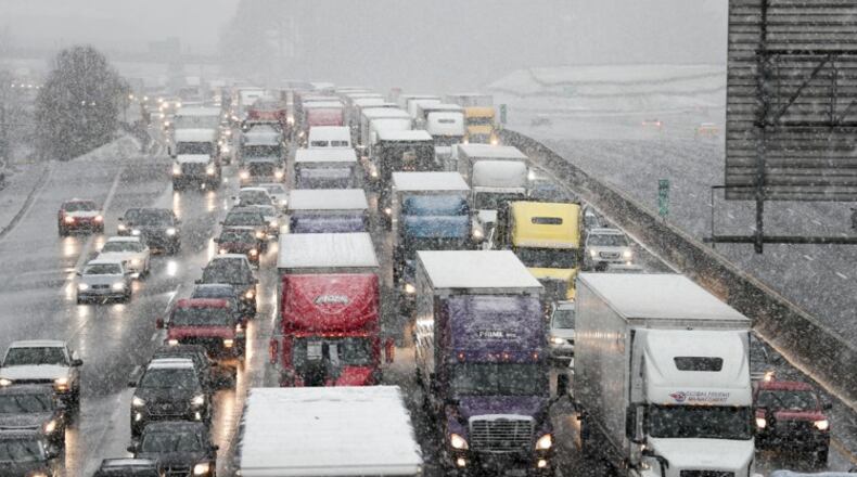 Traffic built up on I-285 Friday as a wintery mixture of sleet fell. Yet again, commuters and school buses poured onto roadways at once when the snow started, but the gridlock was short lived. ALYSSA POINTER/ALYSSA.POINTER@AJC.COM