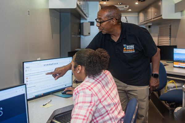 A business service consultant for WorkSource Fulton helps a job seeker with her application.