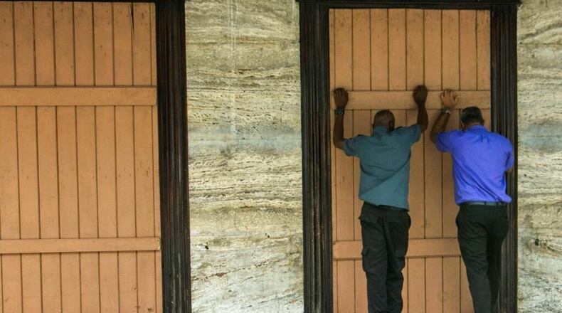 Residents board up a storefront pharmacy as they prepare for the arrival of Tropical Storm Dorian, in Bridgetown, Barbados, Monday, Aug. 26, 2019.