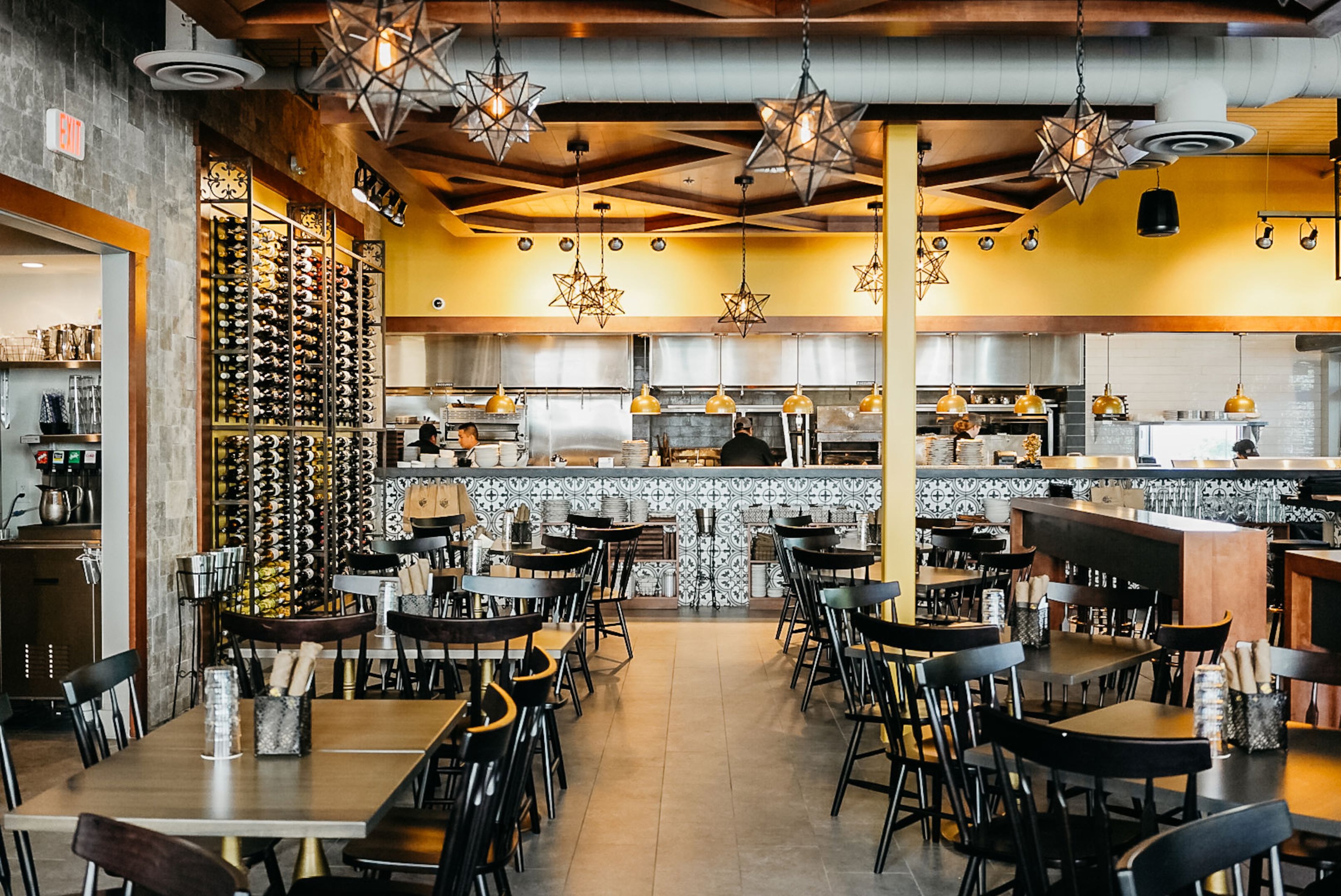 Fogón and Lions' interior features lots of iron, dark woods, stone walls and pops of yellow. (Courtesy of Fogón and Lions)