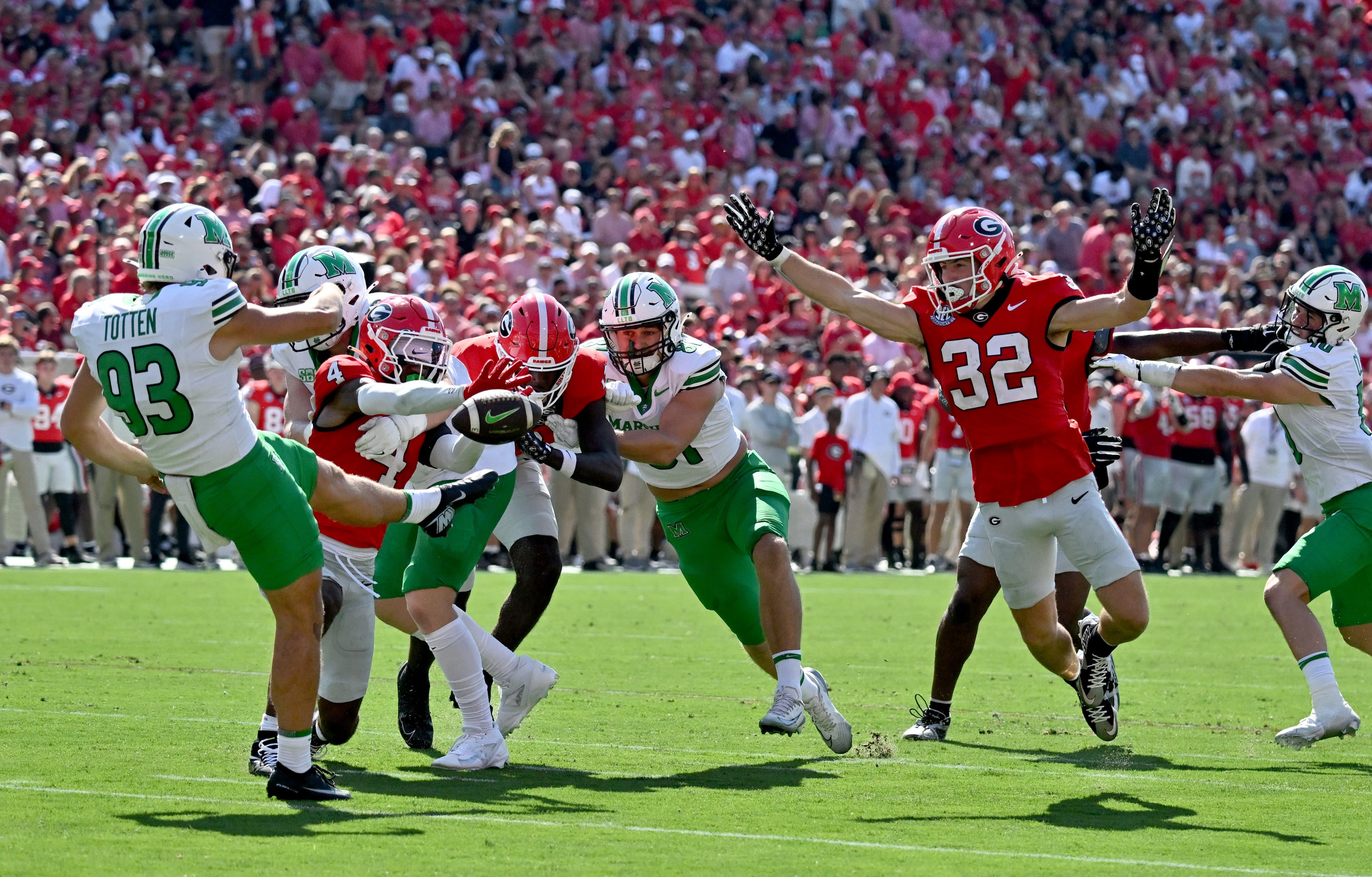 Georgia running back Cash Jones (32) blocks the kick by Marshall place kicker Nathan Totten (93) during the first half in an NCAA football game at Sanford Stadium, Saturday, August 30, 2025, in Athens. (Hyosub Shin / AJC)