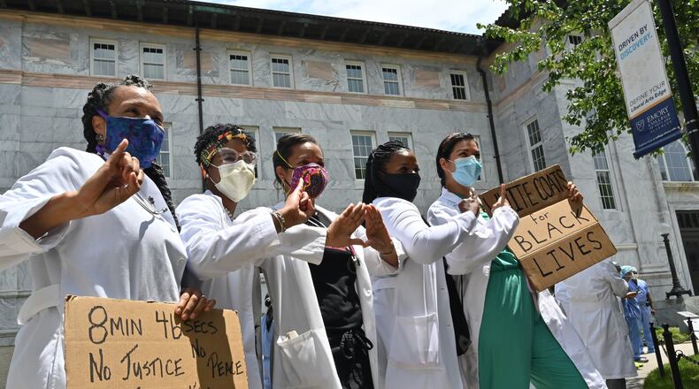 Emory medical students, doctors, nurses and other health care staff gathered to take a knee for eight minutes and 46 seconds in memory of George Floyd “and countless others,” in a demonstration they called White Coats for Black Lives in Decatur on Friday, June 5, 2020. Doctors these days are finding themselves at the intersection of America’s race debate: giving advice to protestors on how to protect their eyes from tear gas and speaking their frustration at seeing people of color disproportionately sickened by COVID-19. (Hyosub Shin / Hyosub.Shin@ajc.com)