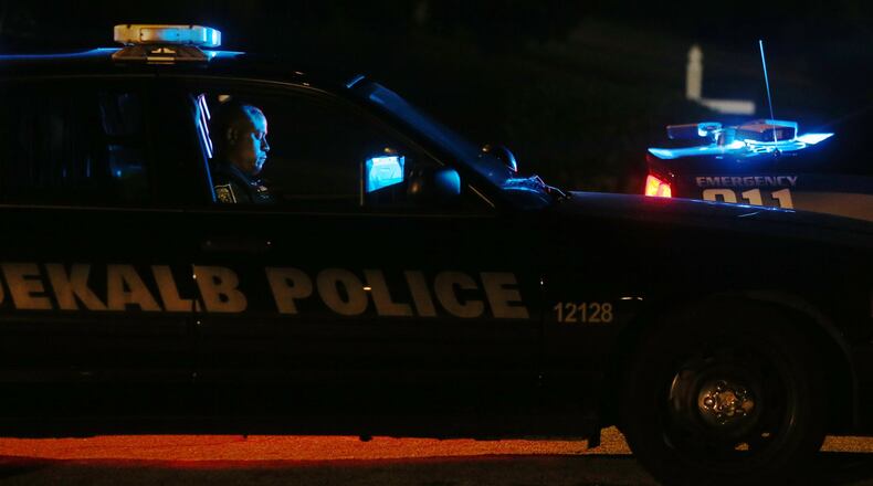 DeKalb County police Officer Phillips sits in his vehicle Thursday at the scene of a shooting that killed a woman and wounded an officer on Hodgdon Corners Cove in Lithonia earlier this month.