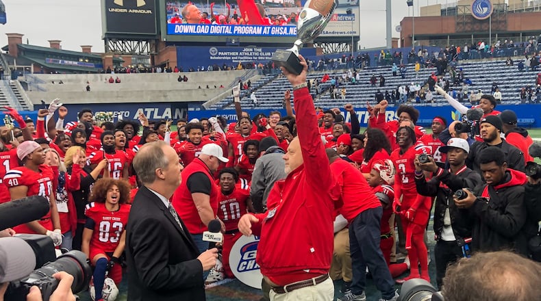 Head Coach Brett Garvin holds up the trophy after his Sandy Creek Patriots win the state football championship. (Courtesy of Fayette County Public Schools)