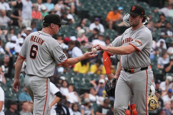 San Francisco Giants manager Bob Melvin, left, takes the ball from relief pitcher pitcher Erik Miller during the seventh inning of a baseball game against the Chicago White Sox in Chicago, Sunday, June 29, 2025. (AP Photo/Nam Y. Huh)
