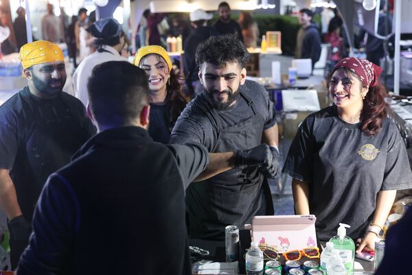Zaid Jagrala, owner of Spicy Stack ATL, greets a customer during the Atlanta Ramadan Food Festival in Norcross on Friday, Feb. 27, 2026. (Arvin Temkar/AJC)