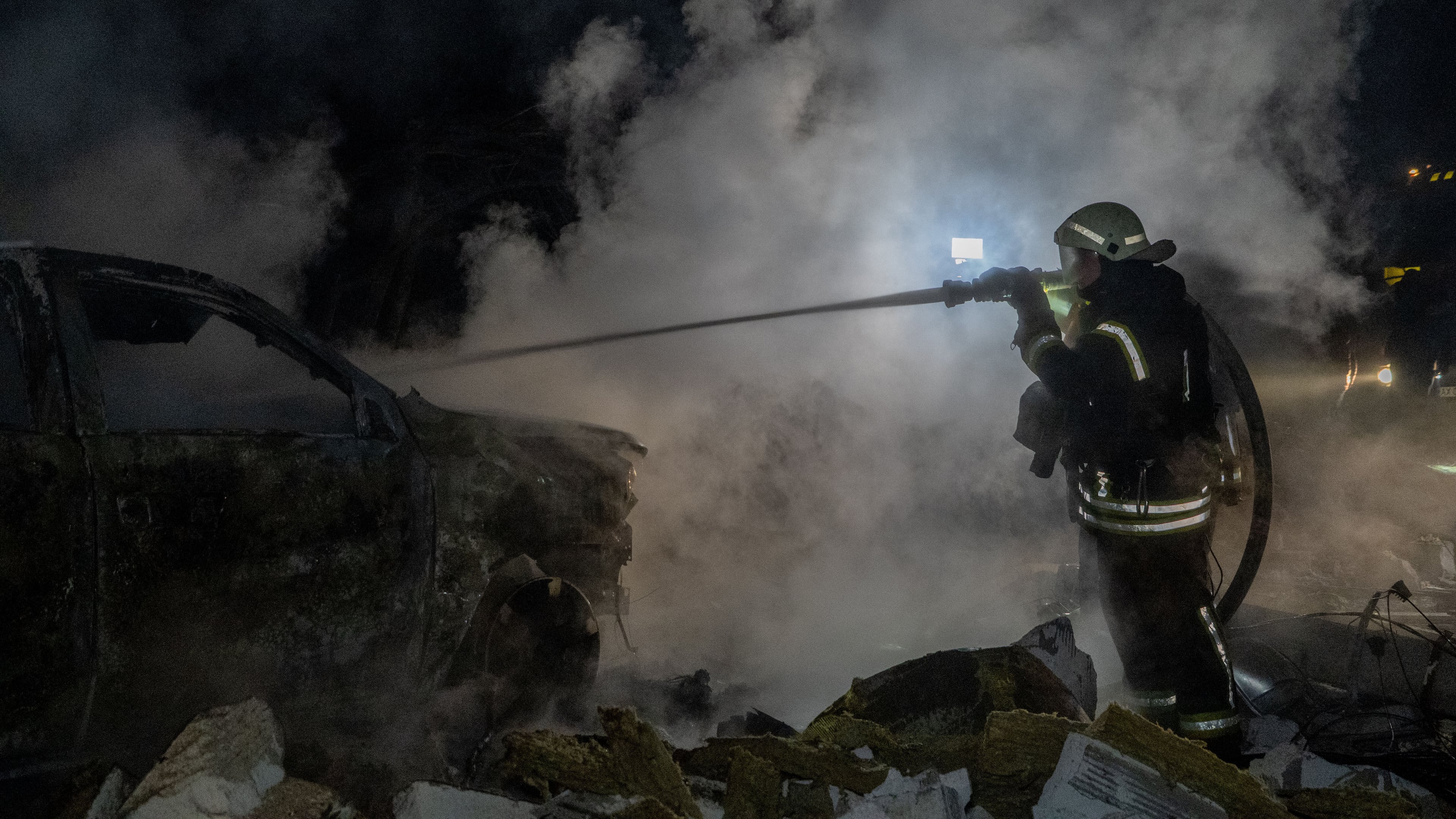 Rescue workers put out a fire of a residential building damaged by a Russian strike in Kharkiv, Ukraine, late Sunday, Nov. 23, 2025. (AP Photo/Andrii Marienko)