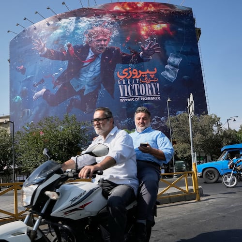 Motorcyclists pass a billboard depicting U.S. President Donald Trump underwater amid explosions, with the words "Great Victory! Strait of Hormuz," in Tehran, Iran, Monday, Aug. 24, 2026. (AP Photo/Vahid Salemi)