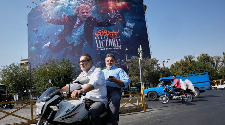 Motorcyclists pass a billboard depicting U.S. President Donald Trump underwater amid explosions, with the words "Great Victory! Strait of Hormuz," in Tehran, Iran, Monday, Aug. 24, 2026. (AP Photo/Vahid Salemi)