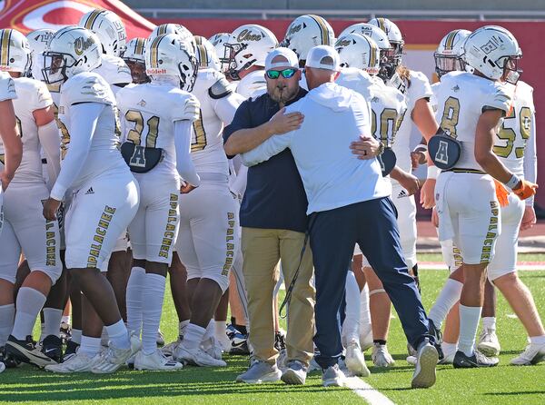 Apalachee coach Mike Hancock embraces strength coach Matt Bradley on Sept. 28, 2024.