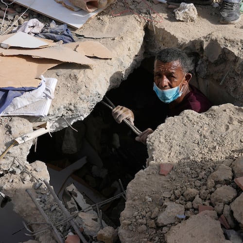 Franklin Fuentes searches for missing relatives in the collapsed building where they lived two days after earthquakes struck La Guaira, Venezuela, Friday, June 26, 2026. (AP Photo/Ariana Cubillos)