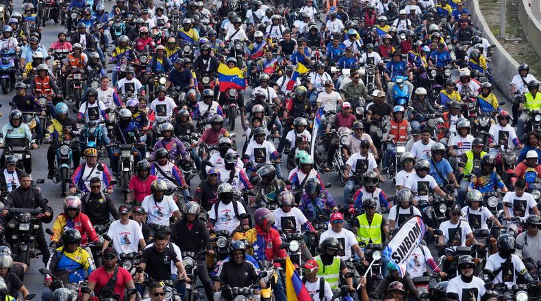 Supporters of former Venezuelan President Nicolas Maduro ride through the streets calling for his release as he faces trial in the United States after being captured by U.S. forces, in Caracas, Venezuela, Tuesday, Jan. 13, 2026. (AP Photo/Matias Delacroix)