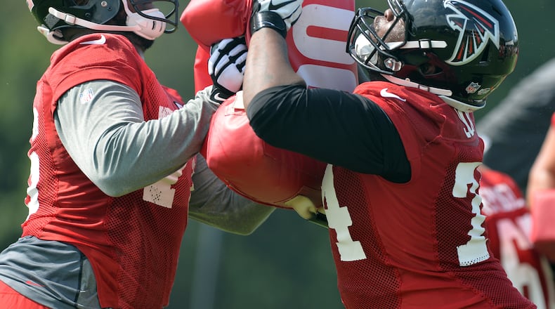 Atlanta Falcons tackles Lamar Holmes, left, and Terren Jones participate in drills during training camp on Friday, July 25, 2014.