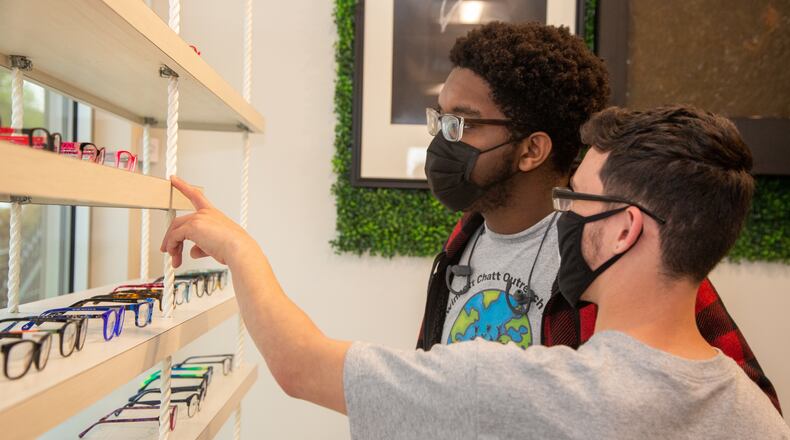Kevin Freeman (left) and Leonard Russell (right) look at eye glasses while visiting First Class Eye Care in Duluth so they can learn about optometry. They were there as part of the "Bridging the Gap" program through nonprofit Gwinnett Chatt Outreach. Ryan Cox founded the nonprofit last year that mostly donates food and other supplies and furthers community relations with the police. But the "Bridging the Gap" program takes groups of high school students around to different businesses around Gwinnett County to show them different career opportunities.
PHIL SKINNER FOR THE ATLANTA JOURNAL-CONSTITUTION.