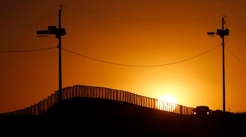 Sunset at the U.S.-Mexico border in Naco, Ariz., where a Border Patrol agent in his car keeps an eye on activity in a 2013 file image. President-elect Trump has vowed to begin construction on the wall soon after his January 20, 2017, inauguration. (Don Bartletti/Los Angeles Times/TNS)