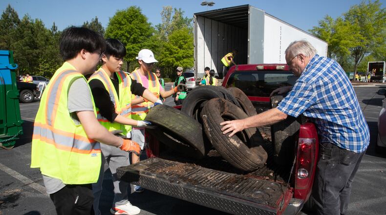 Volunteers help lee Raymond (R) unload tires he brought to Gwinnett County's annual Earth Day event at Coolray Field in Lawrenceville Saturday, April 23, 2022. Each year, Gwinnett County Solid Waste Management and Gwinnett Clean & Beautiful celebrate Earth Day, allowing residents to drop off items typically challenging to recycle, such as electronics, latex, and oil-based paints, clothing, sneakers, and tires. (Steve Schaefer / steve.schaefer@ajc.com)