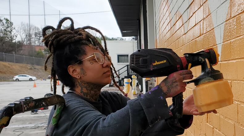 Charity Hamidullah works on one of her Atlanta murals. Photo: Arthur Rudick/Streetartmap.org