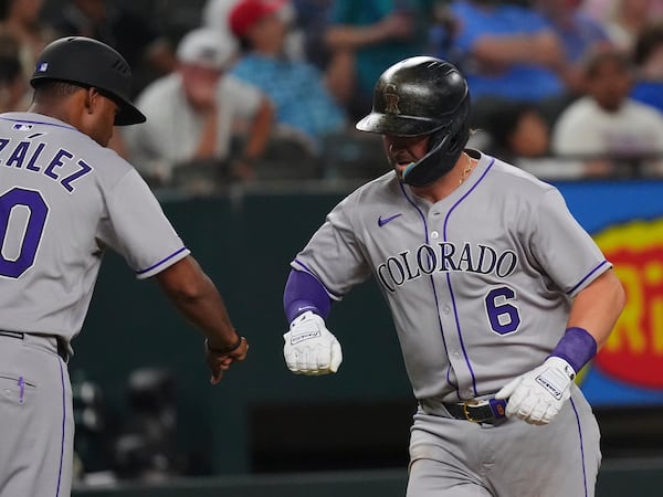 Colorado Rockies' Kyle Farmer (6) celebrates his home run with third base coach Andy González (70) during the sixth inning of a baseball game against the Texas Rangers, Wednesday, May 14, 2025, in Arlington, Texas. (AP Photo/LM Otero)