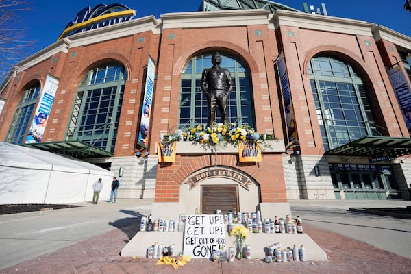 Cans and bottle of beer, along with other items, adorn the base of the the Bob Uecker statue in front of American Family Field following a baseball game between the Milwaukee Brewers and the Kansas City Royals on Opening Day, Monday, March 31, 2025, in Milwaukee. (AP Photo/Kayla Wolf)