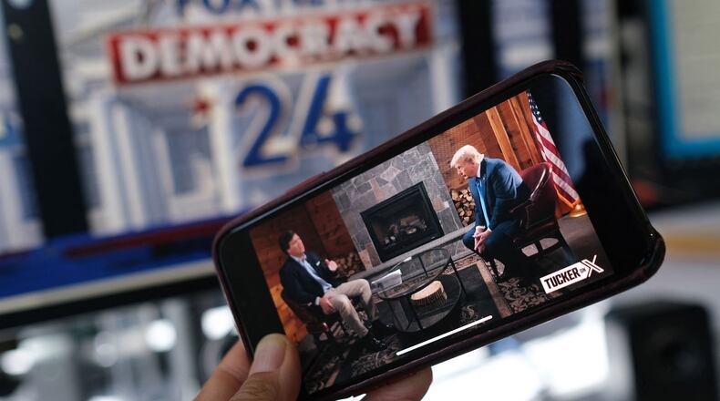 A photo illustration shows a preview on a smartphone of Tucker Carlson's interview of former President Donald Trump scheduled to air on X, formerly Twitter, on the same night of the first Republican Presidential primary debate in Milwaukee on Wednesday, Aug. 23, 2023. (Chris Delmas/AFP/Getty Images/TNS)