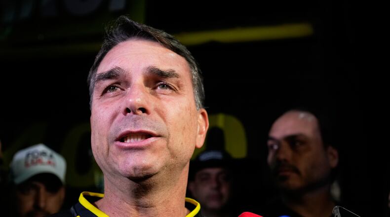 Flavio Bolsonaro, son of ex-President Jair Bolsonaro, speaks during a vigil outside the former president's residence in Brasília, Brazil, Saturday, Nov. 22, 2025, after his father's arrest earlier in the day, carried out days before he was set to start serving his 27-year sentence for leading a coup attempt. (AP Photo/Eraldo Peres)