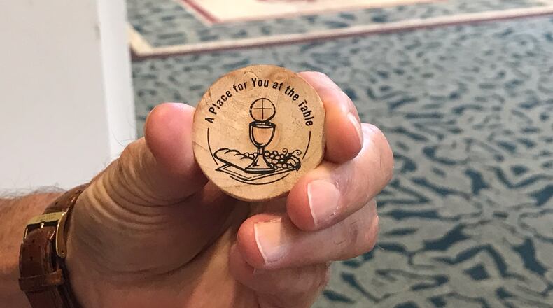 Mike Malone from Greensboro, Ga. holds a wooden token give to delegates at the 2022 meeting of the North Georgia Conference  of the UMC in Athens.