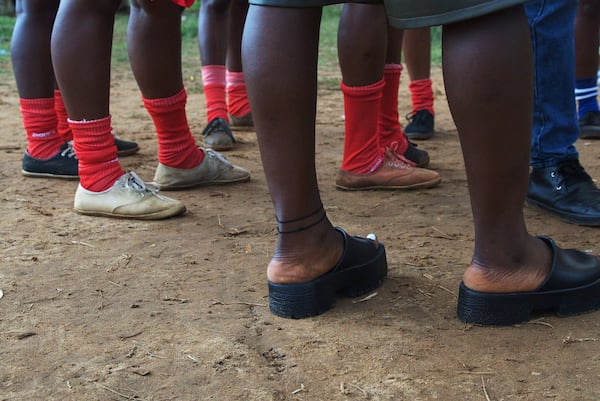 Women on the Girls of Aries kickball team, part of Liberia's professional kickball league, talk together before a match at the Samuel Kanyon Doe Stadium in Monrovia, Liberia, June 14, 2025. (AP Photo/Annie Risemberg)