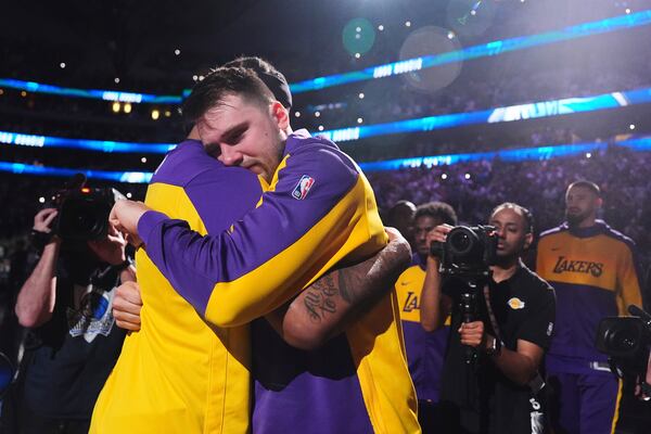 Los Angeles Lakers' Luka Doncic, center right, hugs Markieff Morris, center left, during team introductions before an NBA basketball game against the Dallas Mavericks in Dallas, Wednesday, April 9, 2025. (AP Photo/LM Otero)