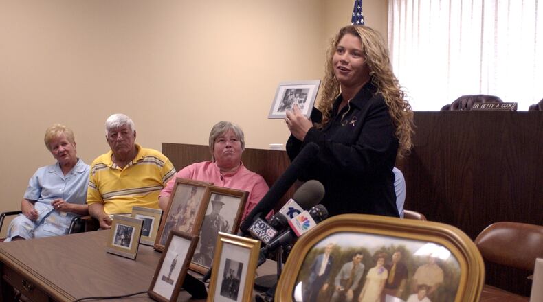 030502 - ATLANTA, GA -- As family members of the Alday's address the press after a parole board clemency hearing for Carl Isaacs who was convicted for the 1973 murders of six Aldays. A rendering of the six Alday's killed is displayed in the foreground. (Special/ JOHN AMIS)
