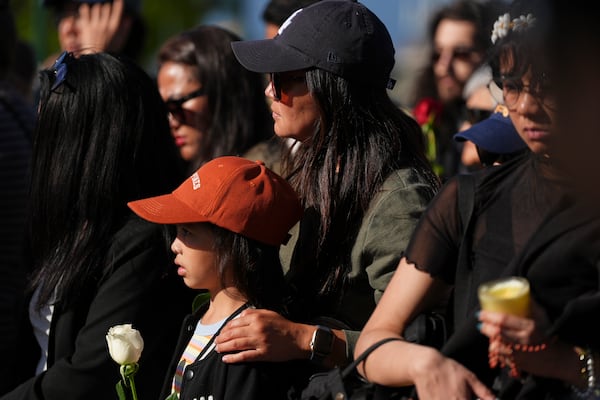 People visit a memorial after a vehicle drove into a crowd during a Filipino heritage festival in Vancouver, British Columbia, Sunday, April 27, 2025. (AP Photo/Lindsey Wasson)