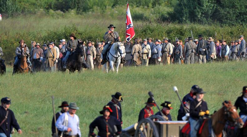 Confederate troops head to the battlefield. Confederate and Union reenactors recreate the Battle of Utoy Creek during the Atlanta Campaign’s Battle of Atlanta re-enactment at the Nash Farm Battlefield Friday, September 19, 2014. KENT D. JOHNSON / KDJOHNSON@AJC.COM