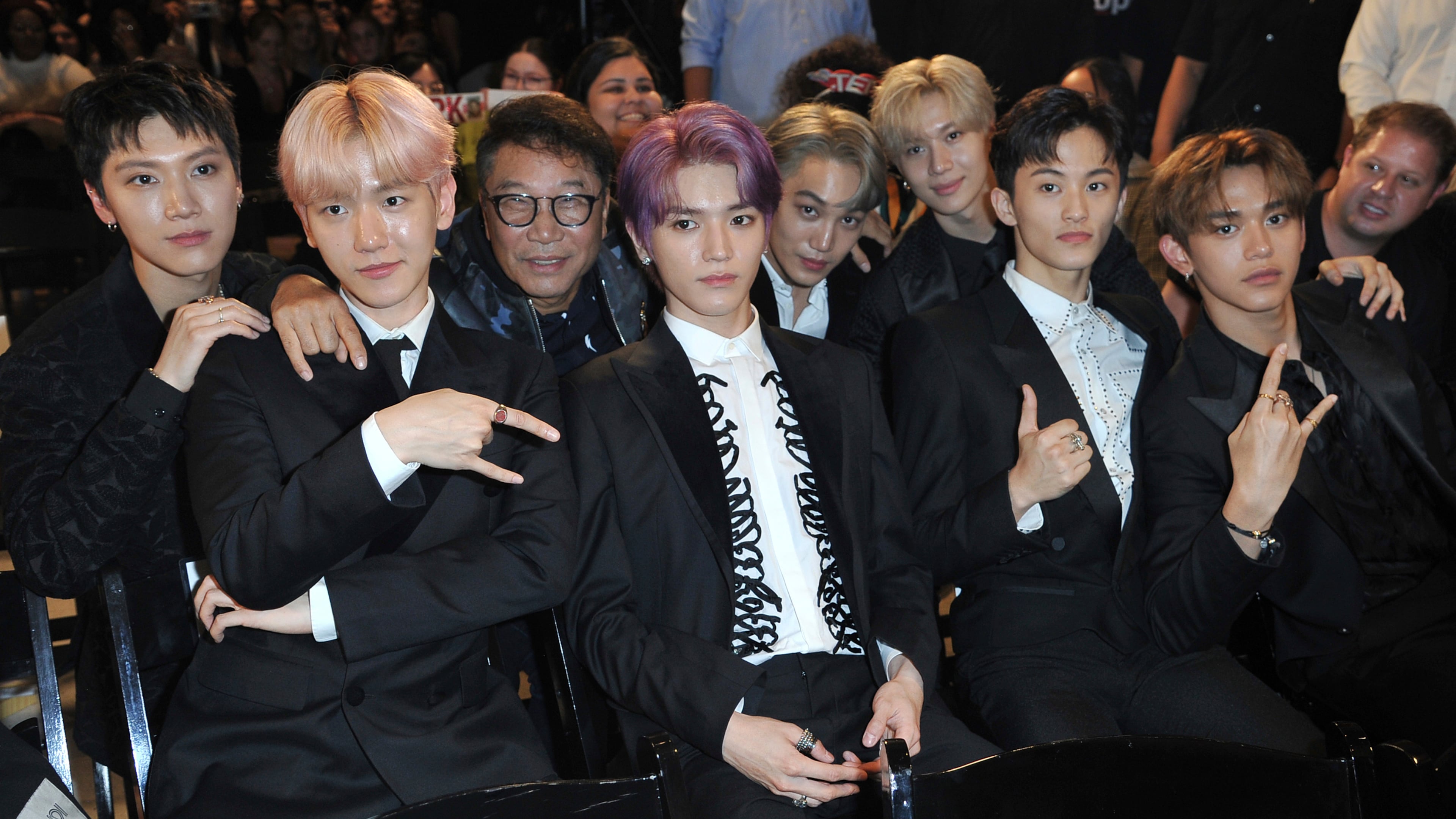 FILE - Producer Lee Soo Man, third from left, and members of SuperM, from left, Ten, Baekhyun, Taeyong, Kai, Taemin, Mark and Lucas sit in the audience to watch the premiere of their music video for their song "Jopping" during a media conference on Oct. 3, 2019, at Capitol Studios in Los Angeles. (Photo by Richard Shotwell/Invision/AP, File)