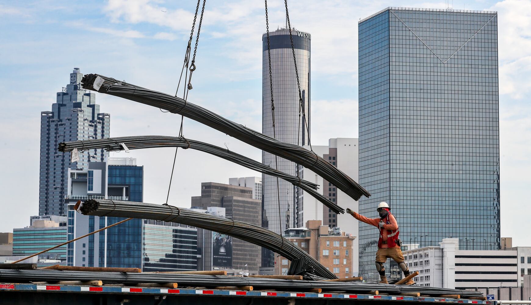 Miguel Flores sends off a bundle of rebar skyward by crane from his flatbed truck on Martin Luther King Jr. Drive in downtown Atlanta as work on the Anthem Hotel Atlanta at Atlanta's $5 billion Gulch redevelopment on Tuesday, Sept. 26, 2023, continued on a mild fall day. (John Spink / John.Spink@ajc.com) 


