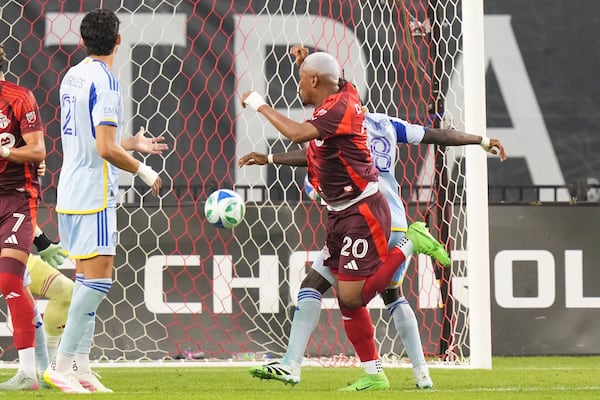Toronto FC's Deybi Flores (20) gets in front of Atlanta United's Tristan Muyumba (8) to score his team's opening goal during second-half MLS soccer match action in Toronto, Saturday, July 12, 2025. (Chris Young/The Canadian Press via AP)