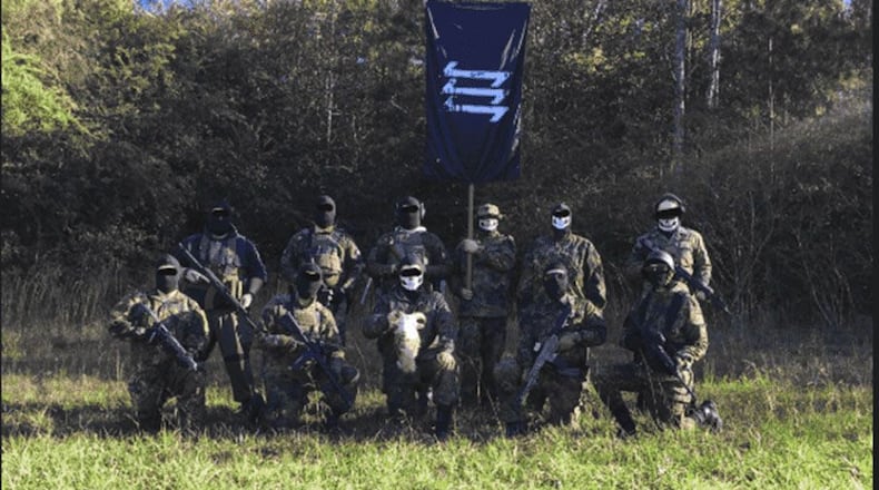 In this photo from a prosecution exhibit, alleged members of the The Base, a far-right terror organization, pose with the severed head of a goat. Eight men have been charged with animal cruelty related to the theft and killing of the animal.