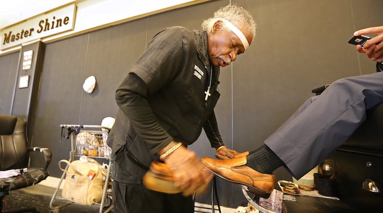 Charles Sanders puts a shine on the shoes of Dom Morea of Sandy Springs at Hartsfield-Jackson International. Sanders co-owns Master Shine, which has the current contract for shoeshine stands. The airport is rebidding the contract for the first time in years and plans to double the number of locations. Curtis Compton /ccompton@ajc.com