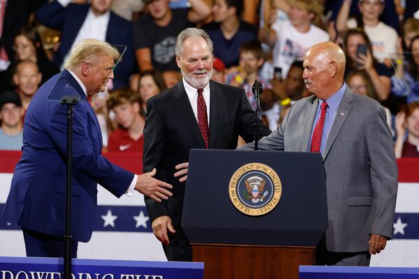 President Donald Trump (from left) greets Braves executive Mike Plant and former Braves manager Brian Snitker at Wheeler High School on Thursday. (Arvin Temkar/AJC)