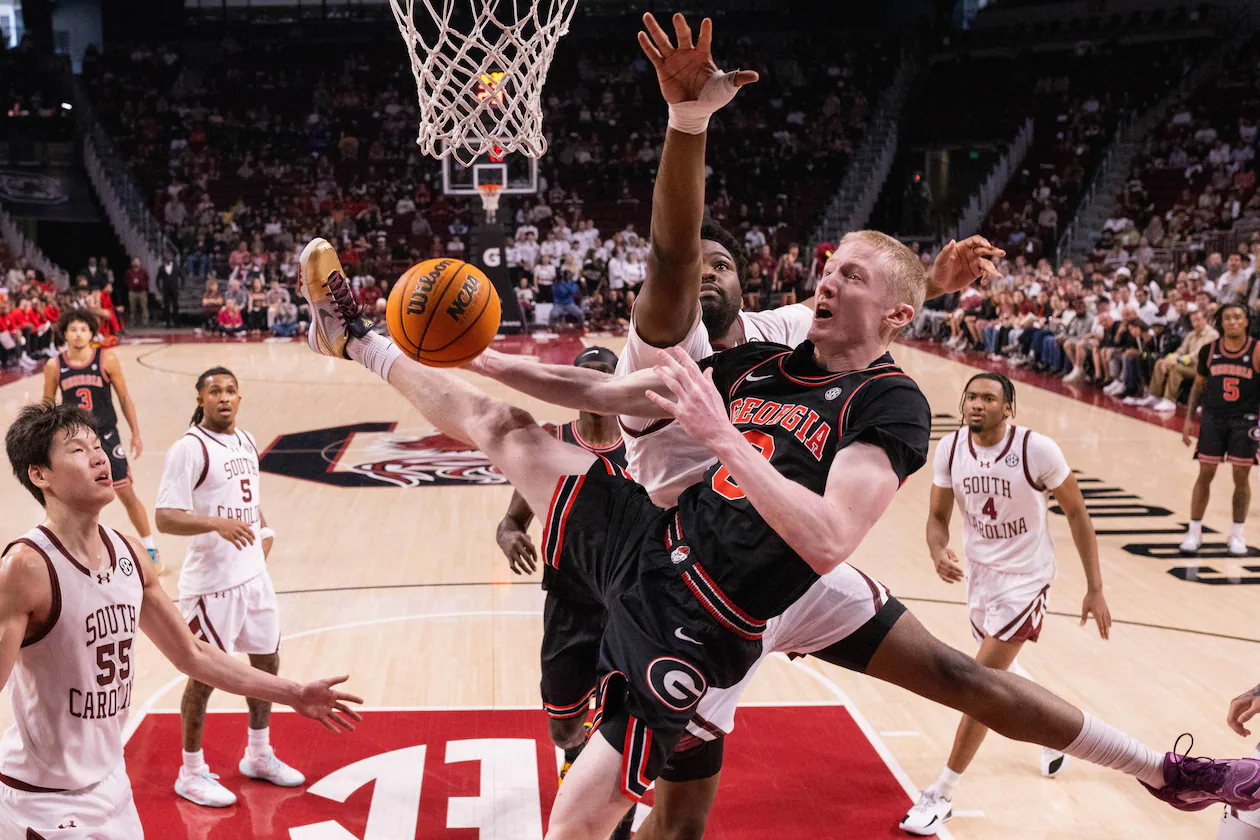Georgia guard Blue Cain gets fouled by South Carolina forward Christ Essandoko during the first half of Saturday's game. (Scott Kinser/AP)